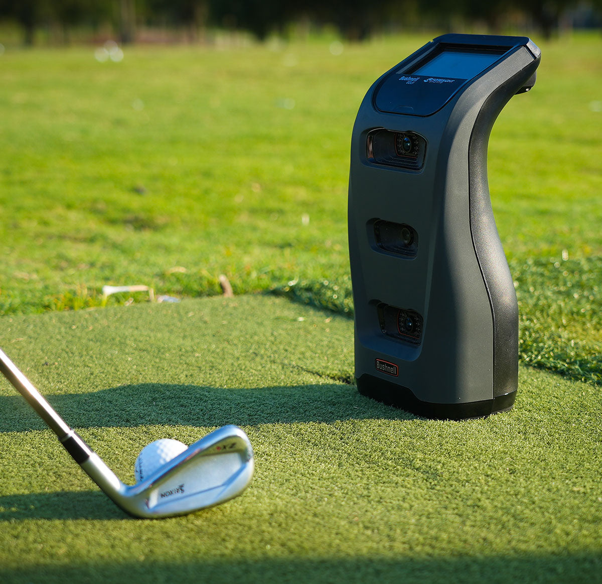 bushnell launch pro golf simulator & launch monitor sitting in front of a ball with a golfer about to take a swing