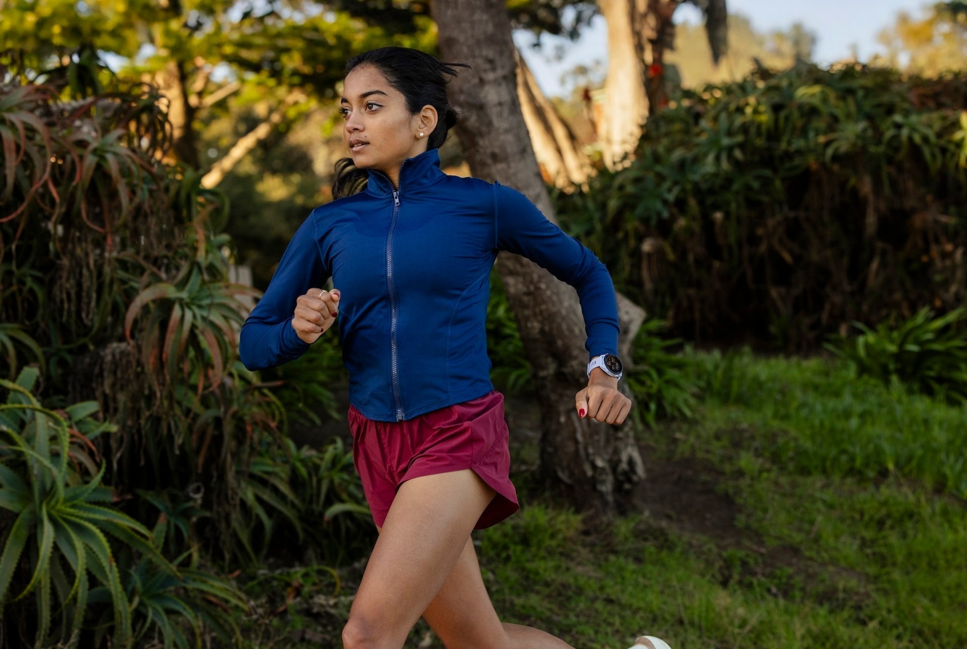 Runner running outdoors with a Garmin Forerunner 70 on her wrist