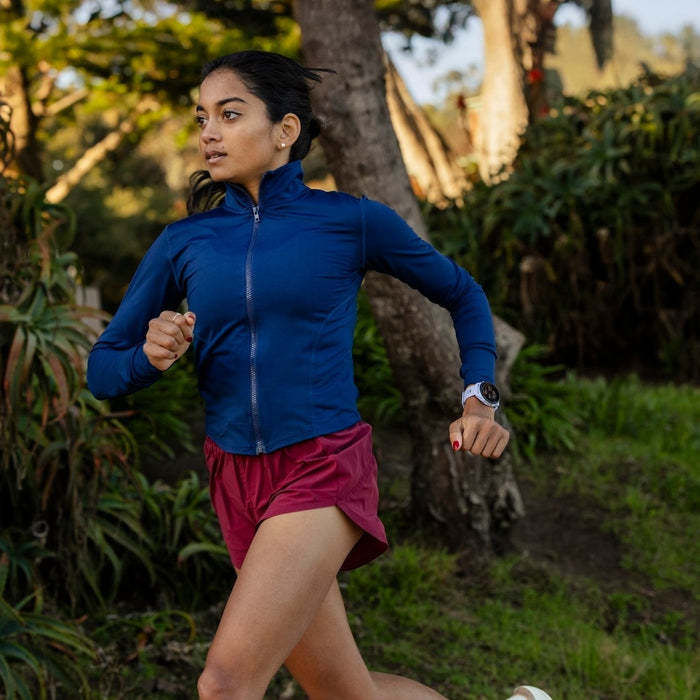 Runner running outdoors with a Garmin Forerunner 70 on her wrist