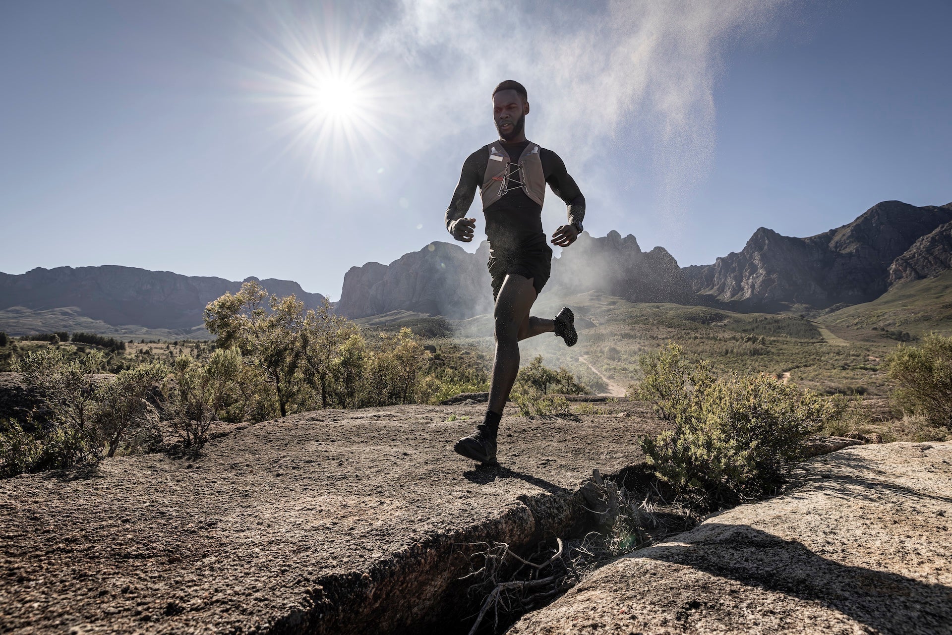 A runner outdoors running in rugged terrain wearing a Garmin fenix 9 Pro