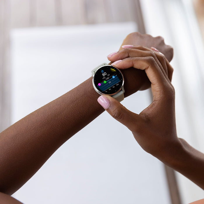 A silver and whitestone Garmin Venu 3 on a female's wrist with one hand adjusting