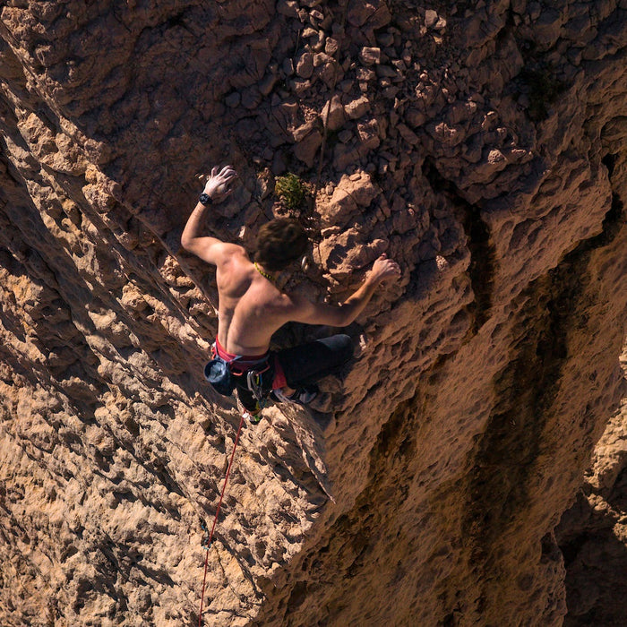 A man rock climbing with a Garmin fenix 8 multisport watch on his wrist