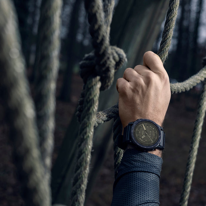 A Garmin tactix 7 AMOLED tactical watch on the wrist of a hand climbing up a rope wall