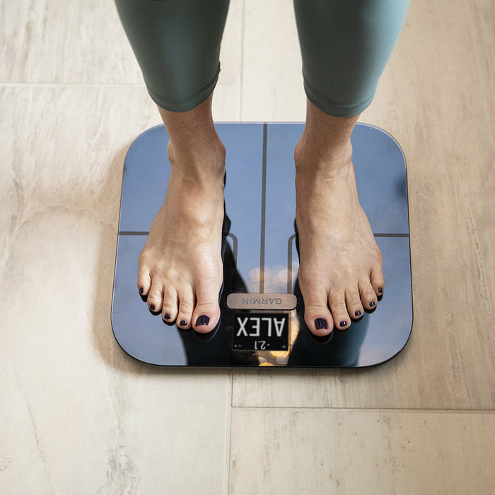 Woman using the Garmin Index S2 Smart Scale to regularly check weight